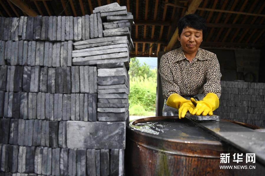 8月15日，在泾县茂林花砖厂，工人在水磨烧制出来的花砖。 花砖是安徽省泾县茂林镇特有的一种古建装饰材料，主要用于门、墙、窗户的装饰。上品花砖呈青白色，不仅花纹清晰、图案雅致，而且具有手感轻柔、不沾灰的特点。明清时期，花砖开始普遍运用于茂林当地民宅中。然而，花砖制作工艺复杂，成本高，加上花砖艺人因躲避战乱流落他乡，花砖制作工艺一度失传。20世纪90年代，茂林人开始重新挖掘花砖制作工艺，逐渐恢复了花砖的生产。如今，花砖制作工艺包括取土、制坯、烧制、水磨等12道大的工序。2014年，花砖制作技艺被列为安徽省省级非物质文化遗产。 新华社记者 刘军喜 摄