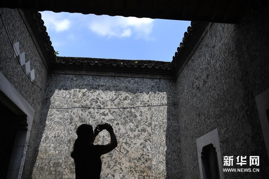 这是泾县茂林镇一民宅内用花砖装饰的墙体（8月15日摄）。 花砖是安徽省泾县茂林镇特有的一种古建装饰材料，主要用于门、墙、窗户的装饰。上品花砖呈青白色，不仅花纹清晰、图案雅致，而且具有手感轻柔、不沾灰的特点。明清时期，花砖开始普遍运用于茂林当地民宅中。然而，花砖制作工艺复杂，成本高，加上花砖艺人因躲避战乱流落他乡，花砖制作工艺一度失传。20世纪90年代，茂林人开始重新挖掘花砖制作工艺，逐渐恢复了花砖的生产。如今，花砖制作工艺包括取土、制坯、烧制、水磨等12道大的工序。2014年，花砖制作技艺被列为安徽省省级非物质文化遗产。 新华社记者 刘军喜 摄