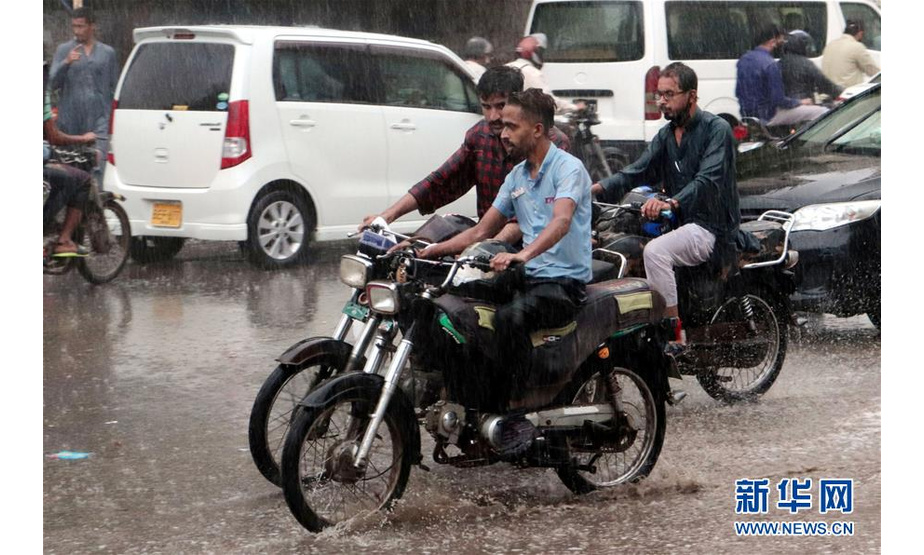 7月6日，人们在巴基斯坦卡拉奇驾驶车辆冒雨前行。 据当地媒体6日报道，由于雨季到来，巴基斯坦卡拉奇因强降雨天气而引发的事故已导致至少7人死亡、数十人受伤。 新华社发