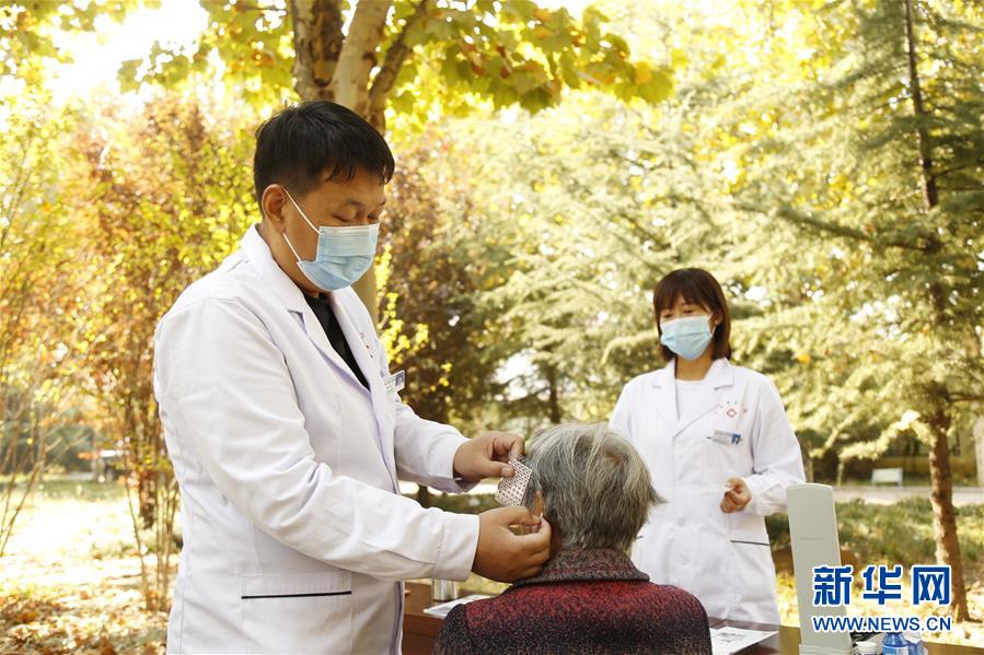 10月24日，河北省邢台市南和区三思乡卫生院医务人员用耳穴压豆法为南韩村老人治疗。 新华社发（张驰 摄）
