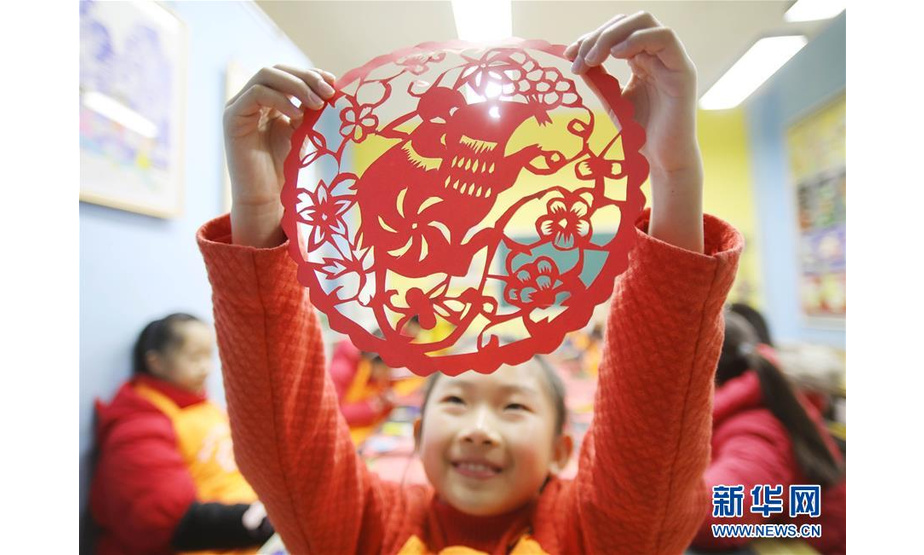 1月19日，在湖南省永州市道县一家美术工作室，一名女孩展示生肖剪纸作品。 鼠年春节临近，孩子们通过亲手制作生肖主题的灯笼，感受传统民俗文化的魅力。 新华社发（何红福 摄）