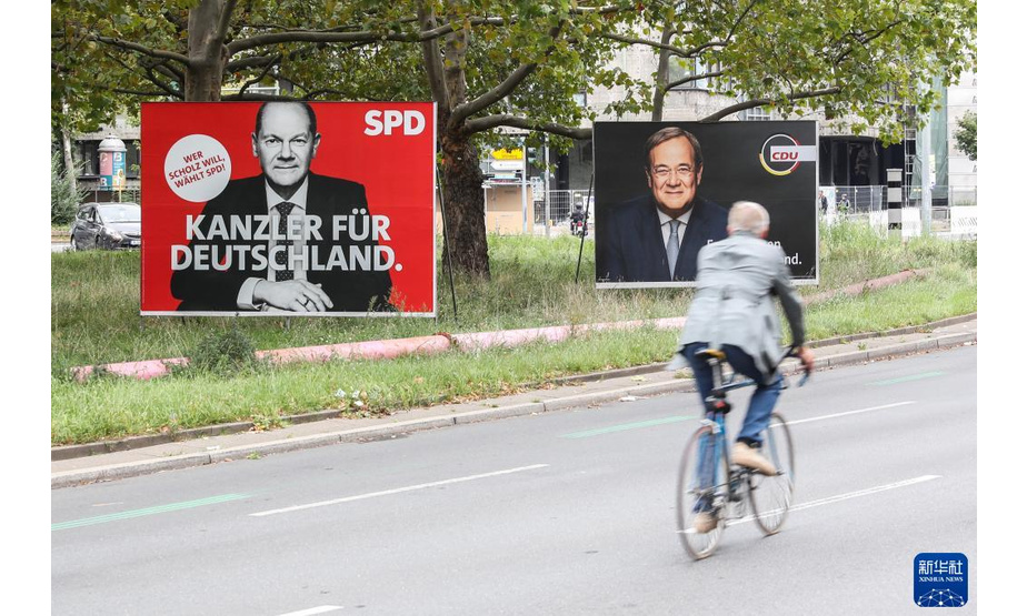 9月25日，在德国首都柏林，一名骑行者经过社民党总理候选人肖尔茨（左）与联盟党总理候选人拉舍特的竞选海报。

　　四年一度的德国联邦议院选举将于9月26日举行，新一届德国政府将基于选举结果组建。

　　新华社记者 单宇琦 摄