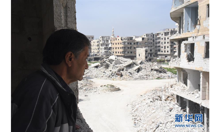 3月12日，在叙利亚大马士革东古塔地区，当地居民萨米尔·加巴里望向楼房废墟。 新华社发（胡马姆·谢赫·阿里 摄）