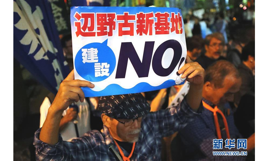 9月19日，在日本东京，一名民众手持标语参加集会。当日，近5000人在东京日比谷公园内参加反对新安保法集会。新华社记者 杜潇逸 摄