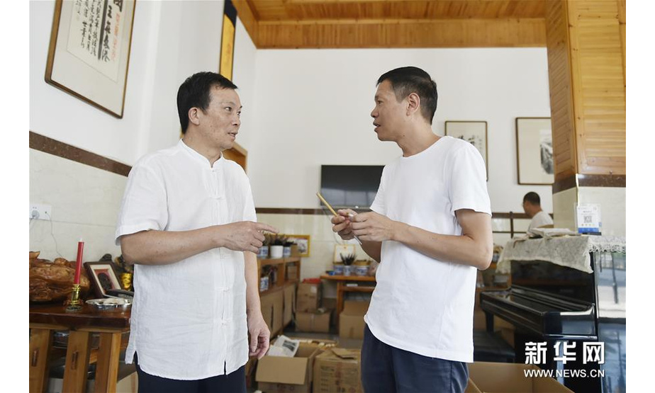 8月8日，周鹏程（左）在自己的笔庄内向来访者介绍毛笔的制作技艺。新华社记者 鲁鹏 摄