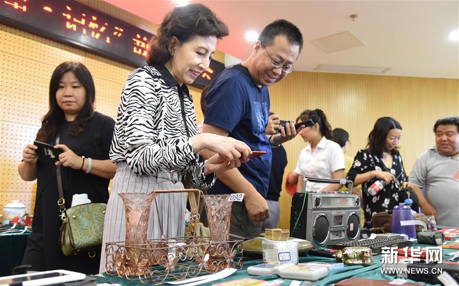 8月14日，社区群众代表在参观老物件展览。 当日，以“城市记忆·学院路故事”为主题的老物件、老照片展览评选活动在北京市海淀区学院路街道市民中心多功能厅举行。 据了解，本次活动共展出100余件老物件、100余张老照片，来自29个社区的代表组成的评审团对展品进行评选。活动旨在唤起社区居民的城市记忆，见证改革开放的巨大变化，进一步增强社会公众的档案参与意识、保护意识和利用意识。 新华社发（任超摄）