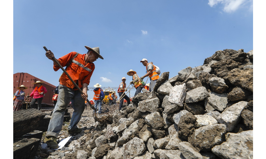 8月4日，鹰潭工务机械段的工作人员对铁轨上的石砟进行清理。