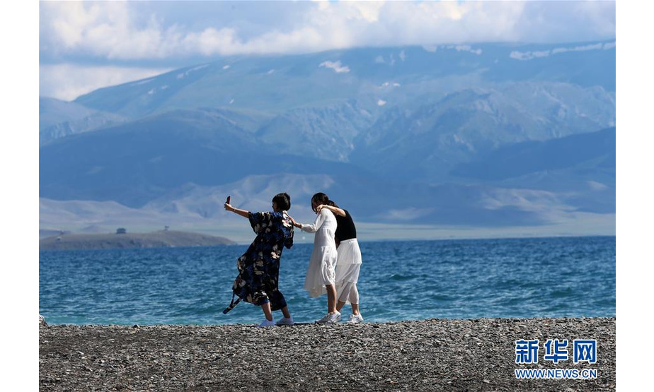 7月18日，游客在新疆赛里木湖湖畔留影。  新华社发（许丛军 摄）
