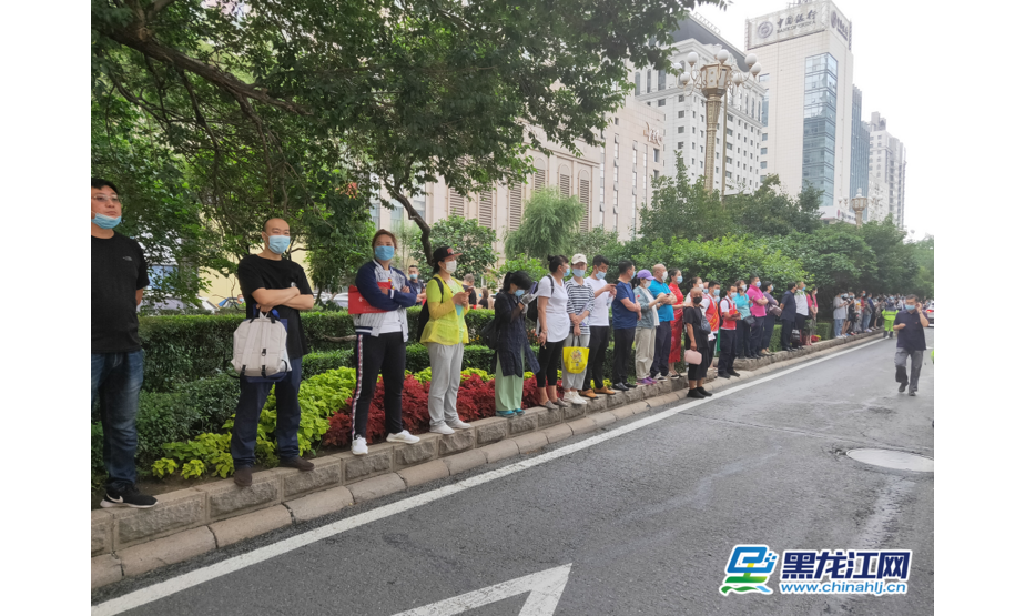 8点15分，哈尔滨市第一中学考点，家长站满兆麟街马路中间的花坛上。彭植 摄影