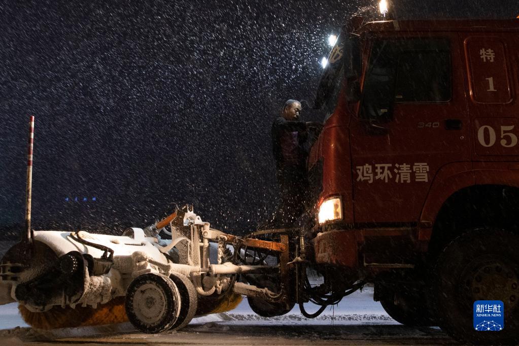 11月21日晚，清雪车司机在鸡西市鸡冠区鸡东新路上对车辆进行清理。

　　黑龙江省鸡西市气象局于11月22日03时50分将暴雪橙色预警信号升级为暴雪红色预警信号。为保障当地物资运输畅通、居民出行便利，鸡西市相关部门迅速组织除雪力量，一夜无眠的“逆行者”在暴雪中用自己的辛苦付出，保障城市有序运转和居民正常生活。

　　新华社记者 张涛 摄