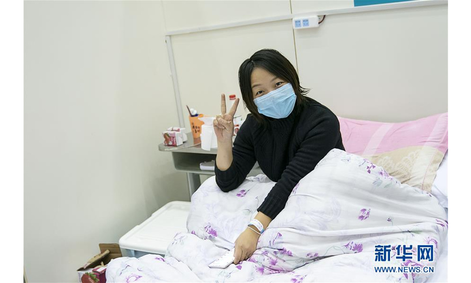 2月10日，在武汉客厅方舱医院，一名患者对记者比出胜利的手势。 武汉方舱医院从2月5日收治首批患者以来，运行平稳有序，患者在医护人员的精心照顾下调养身体，等待痊愈。 新华社记者 熊琦 摄