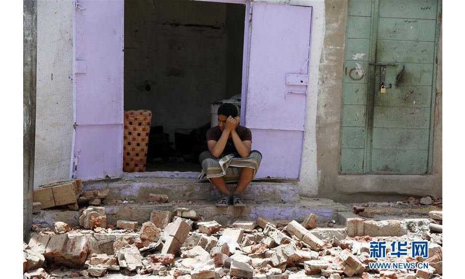 5月16日，在也门首都萨那，一名男子坐在遭空袭的房屋门口。 也门胡塞武装16日说，沙特阿拉伯领导的多国联军当天对也门首都萨那实施密集空袭，造成至少6名平民死亡。 新华社发（穆罕默德 摄）