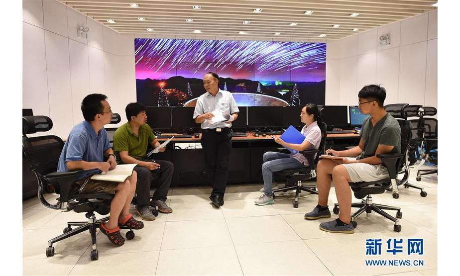 工作人员在FAST总控室内交流（2017年8月10日摄）。自2016年9月25日落成启用以来，500米口径球面射电望远镜——“中国天眼”共发现51颗脉冲星候选体，其中有11颗已被确认为新脉冲星。新华社记者 欧东衢 摄