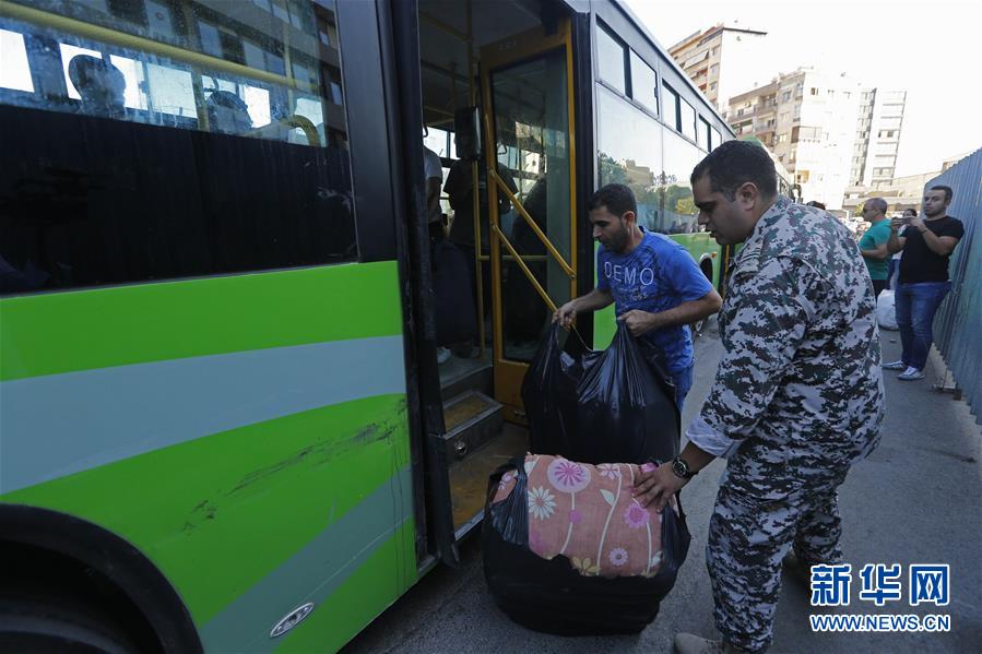 10月10日，在黎巴嫩首都贝鲁特，叙利亚难民登上返乡的客车。 当日，近1000名叙利亚难民从黎巴嫩贝鲁特和的黎波里等城市出发，踏上返乡路。 新华社发（比拉尔·贾维希摄）