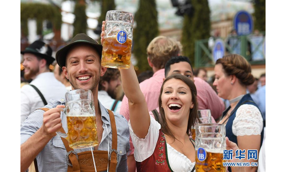 9月21日，人们在德国慕尼黑啤酒节上享用啤酒。 当日，第186届慕尼黑啤酒节在德国南部城市慕尼黑开幕。作为德国最大的民间盛事，本届啤酒节将持续至10月6日。 新华社记者 逯阳 摄