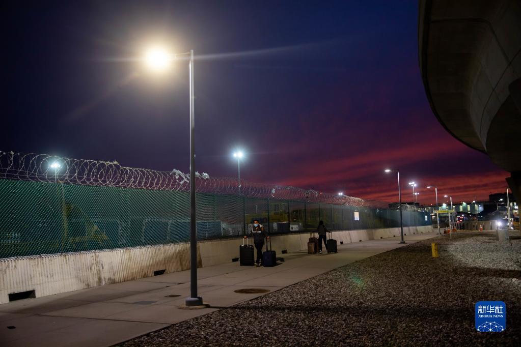 1月3日，在美国纽约肯尼迪国际机场，两名旅客拉着行李前往航站楼。

　　受疫情和天气情况影响，美国近期有数以千计航班被取消。

　　新华社发（郭克摄）