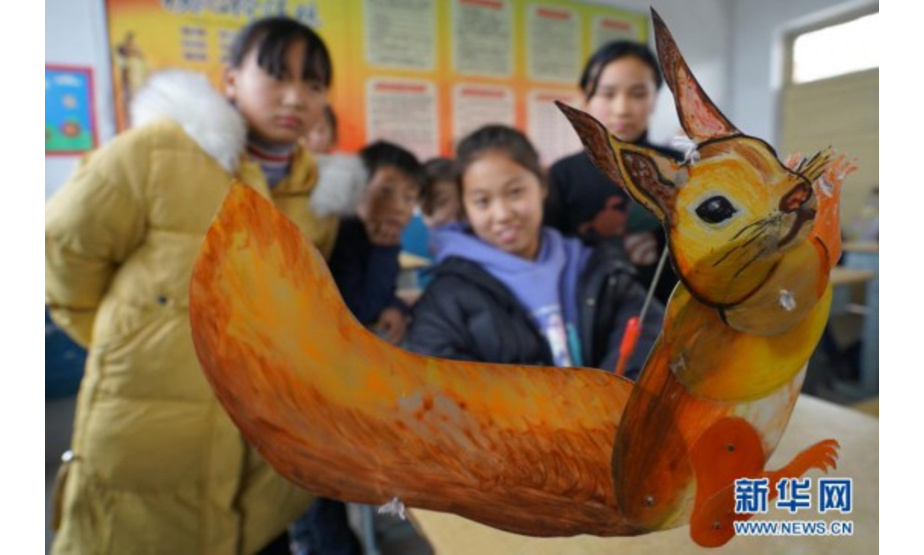 11月24日，河北省沙河市西油村小学学生在观看皮影戏表演道具。