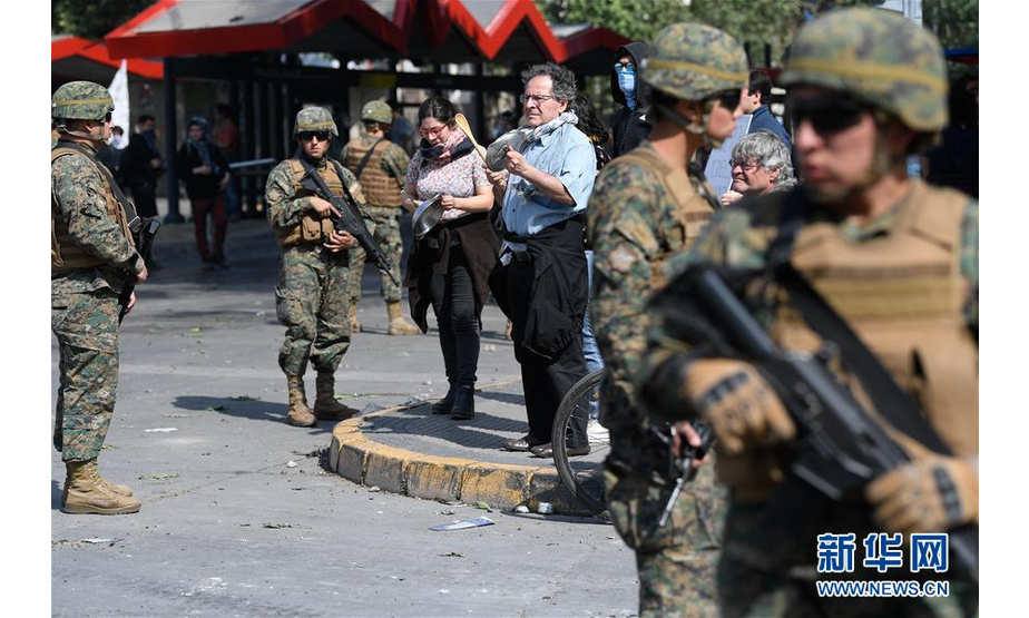 10月19日，在智利圣地亚哥，军方在街头警戒。 智利军方19日晚宣布在首都圣地亚哥实施宵禁，以避免因公交系统涨价引发的暴力抗议进一步升级。智利内政部长安德烈斯·查德威克20日说，首都圣地亚哥以外城市也出现了暴力破坏行为，康塞普西翁和瓦尔帕莱索市已进入紧急状态，他表示已经采取并将继续采取措施以保障社会秩序和公民安全。 新华社发（豪尔赫·比列加斯摄）