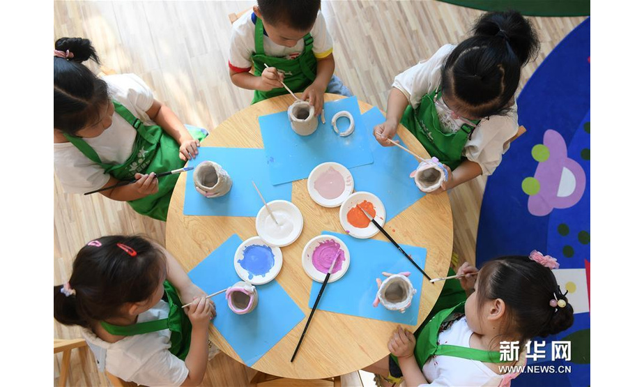 8月19日，小朋友在给陶艺作品上釉。新华社记者翁忻旸摄
