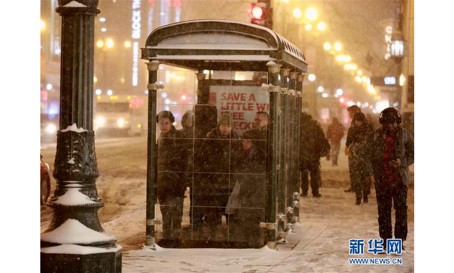 1月17日，在美国芝加哥，人们在雪中等待公共汽车。 美国芝加哥当日遭暴风雪袭击，地面积雪严重，影响交通和出行。 新华社记者 汪平 摄