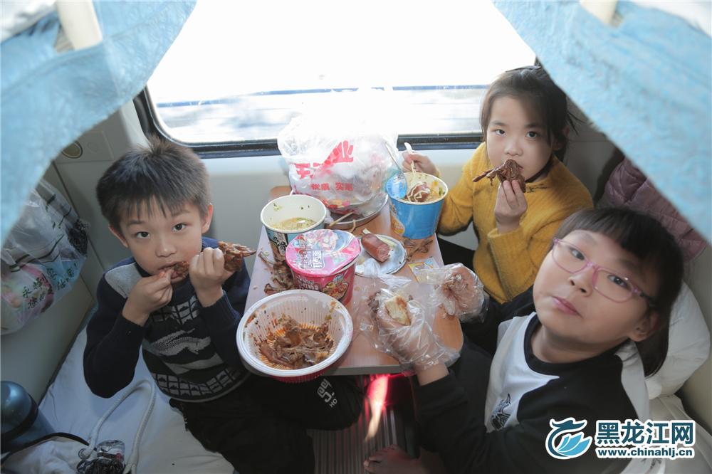 坐在火车上吃着泡面成了孩子们的最美味的食物。 石启立 摄