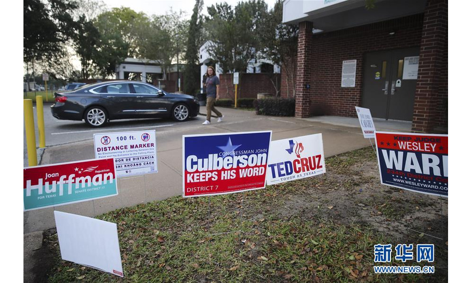 11月6日，一名选民从美国得克萨斯州休斯敦的一个投票站外的竞选广告旁走过。美国6日举行2018年中期选举。 新华社记者 王迎 摄