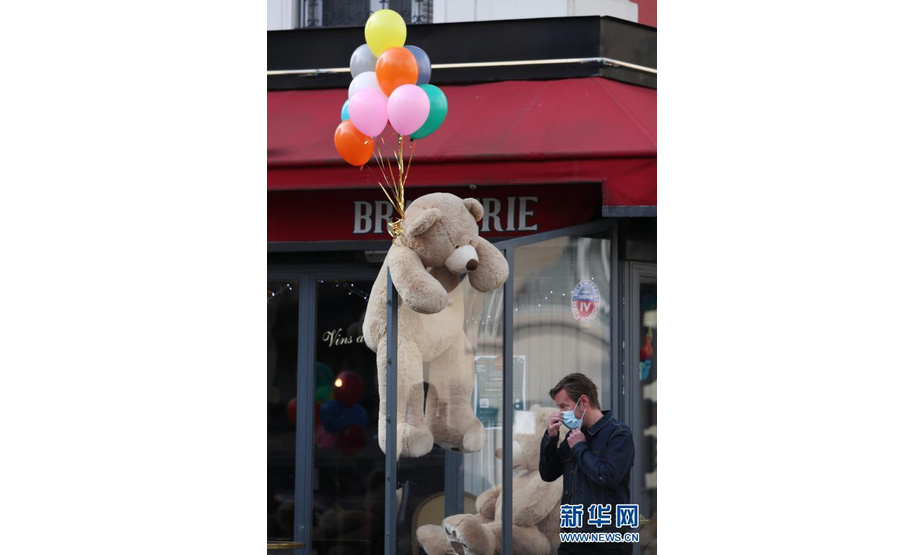 3月3日，一名男子走过法国巴黎街头一家餐馆外的玩具熊。新华社记者 高静 摄
