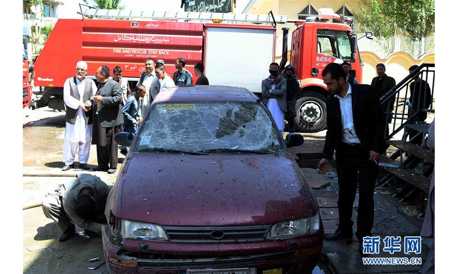 4月22日，在阿富汗首都喀布尔，市民在爆炸现场查看一辆被毁坏的汽车。阿富汗公共卫生部消息人士22日说，阿首都喀布尔当天上午发生一起爆炸事件，造成至少4人死亡、15人受伤。爆炸地点位于喀布尔西部达什特巴尔奇街区的一个选民注册站附近。受伤人员已被陆续送往附近医院接受救治。新华社记者 代贺 摄