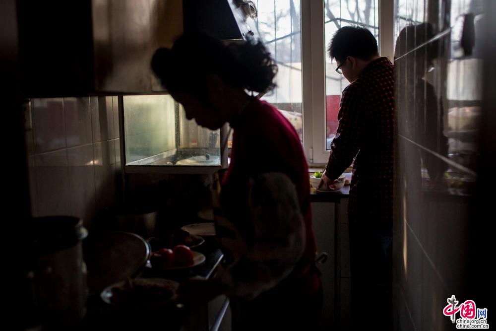 妈妈继续炒着热菜，帮不上忙的自己只能在一旁拌着凉菜，“香油别放太多，拌的时候一定要拌匀，别弄撒了……”妈妈一边炒菜一边叮嘱着，也许是好久厨房里没有多一个人了，妈妈的话变的多起来，这个感觉，有些温暖。中国网记者 郑亮 摄