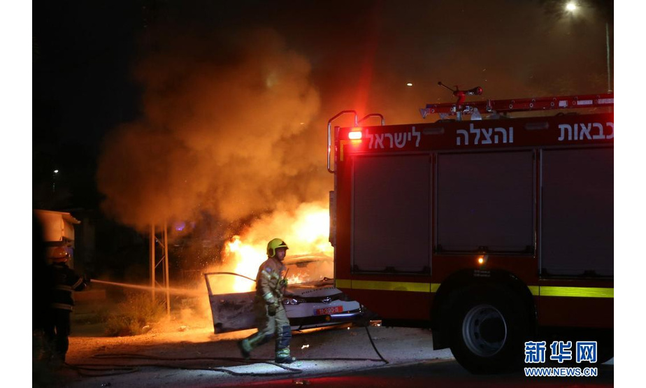 5月12日，在以色列中部城市卢德，消防员为一辆燃烧的警车灭火。

　　以色列总理办公室12日凌晨发表声明宣布，以中部阿拉伯人与犹太人混居城市卢德进入紧急状态。

　　新华社发（穆阿迈尔·阿瓦德摄）
