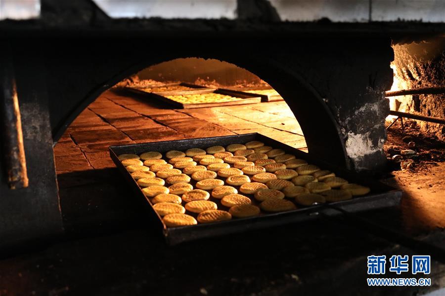 这是8月21日在伊拉克巴格达一家面包店拍摄的烤制中的“克莱佳”。新华社发（哈利勒·达伍德摄）