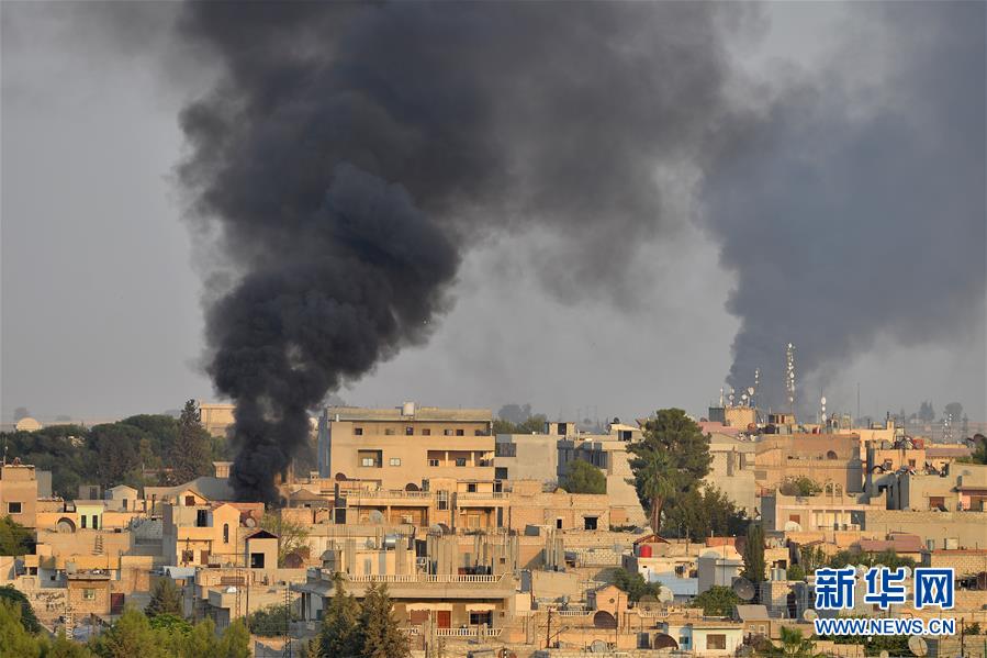 这是10月9日在土耳其边境的杰伊兰珀纳尔附近拍摄的遭到土军炮击的叙利亚拉斯艾因市。新华社发（穆斯塔法·卡亚摄）