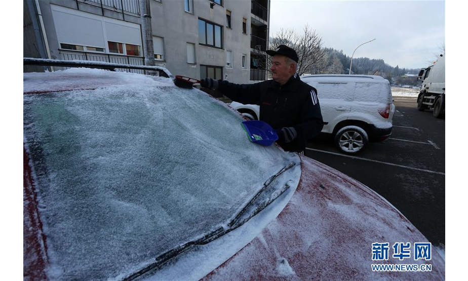 12月3日，在克罗地亚西部山区小镇代尔尼采，一名男子除去汽车上的冰雪。 新华社发（戈兰·科瓦契奇摄）