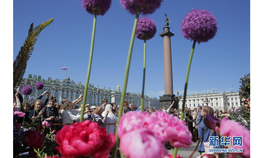 6月12日，人们在俄罗斯圣彼得堡街头参加鲜花大游行，庆祝“俄罗斯日”。  新华社发（莫京娜 摄）