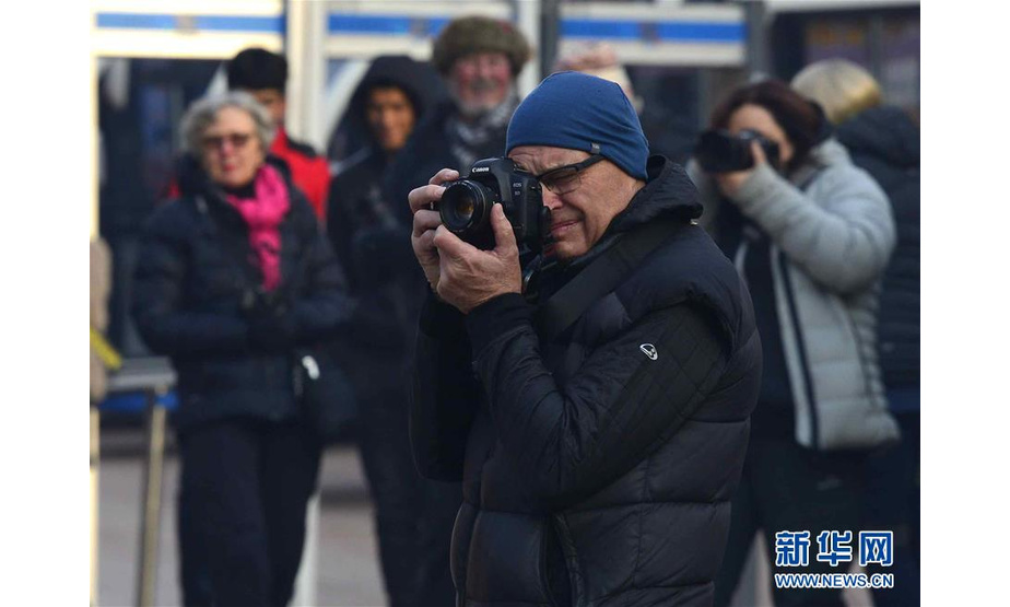 12月9日，来自澳大利亚的游客在喀什古城景区内游玩拍照。  新华社发（阿地力江·阿不都卡德尔 摄）