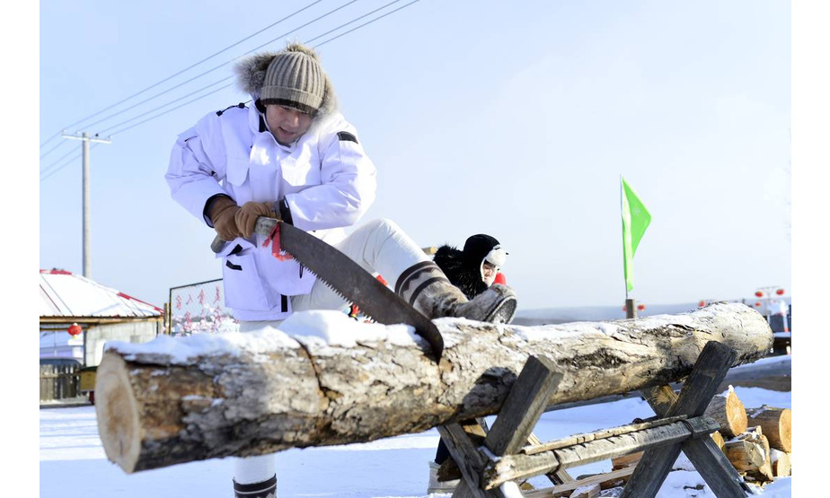 1月17日，游客在“冷极村”体验锯木头。      

“冷极村”位于内蒙古自治区呼伦贝尔根河市金河镇，是中国气温最低的地区之一，冬天经常出现－40℃以下的天气。寒冬腊月，村里推出狗拉雪橇、冰雪秋千、泼水成冰、锯木头体验等多项特色冰雪旅游项目，吸引游客到此观光游览，感受冰雪风情。