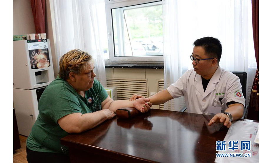 8月10日，绥芬河市人民医院的医生在给一名俄罗斯患者诊脉。新华社发（谢剑飞摄）