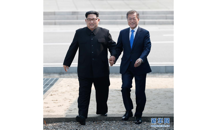 4月27日，朝鲜最高领导人金正恩（左）在板门店跨过军事分界线，与韩国总统文在寅会晤。 新华社发（韩朝首脑会晤媒体报道团供图）