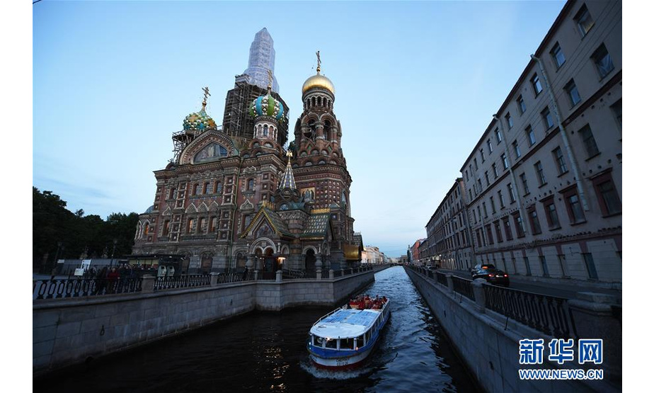 2019年6月3日，在俄罗斯圣彼得堡市，人们乘船经过滴血教堂。 建于1703年的圣彼得堡是俄罗斯第二大城市，位于波罗的海芬兰湾东端的涅瓦河三角洲。第一次世界大战爆发后，圣彼得堡被改名为彼得格勒。1924年1月列宁逝世后，该城又改称列宁格勒。1991年，这座城市恢复了它的原名圣彼得堡。 新华社记者 沙达提 摄