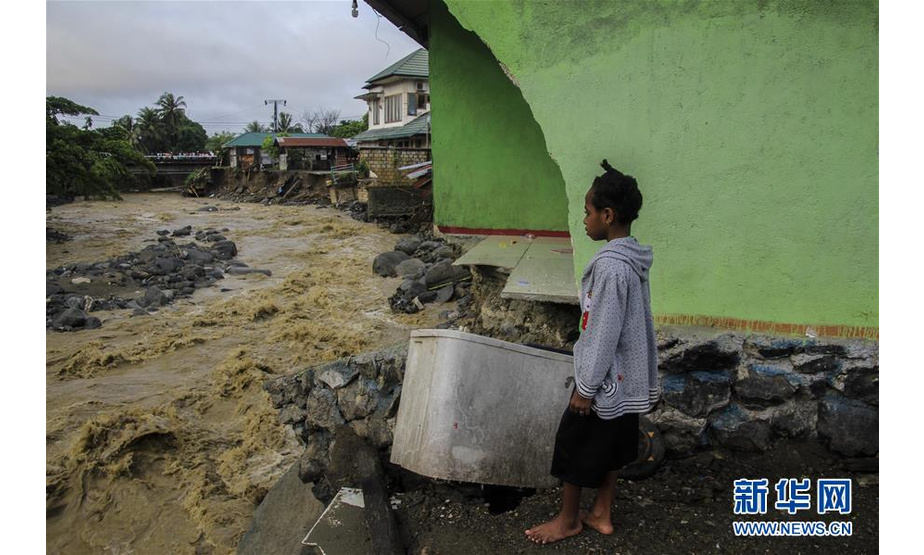 3月17日，在印度尼西亚巴布亚省森塔尼，一名女孩站在被洪水冲垮的建筑旁。印度尼西亚抗灾署17日说，印尼东部巴布亚省16日晚发生的洪涝灾害已导致42人死亡、21人受伤。新华社发