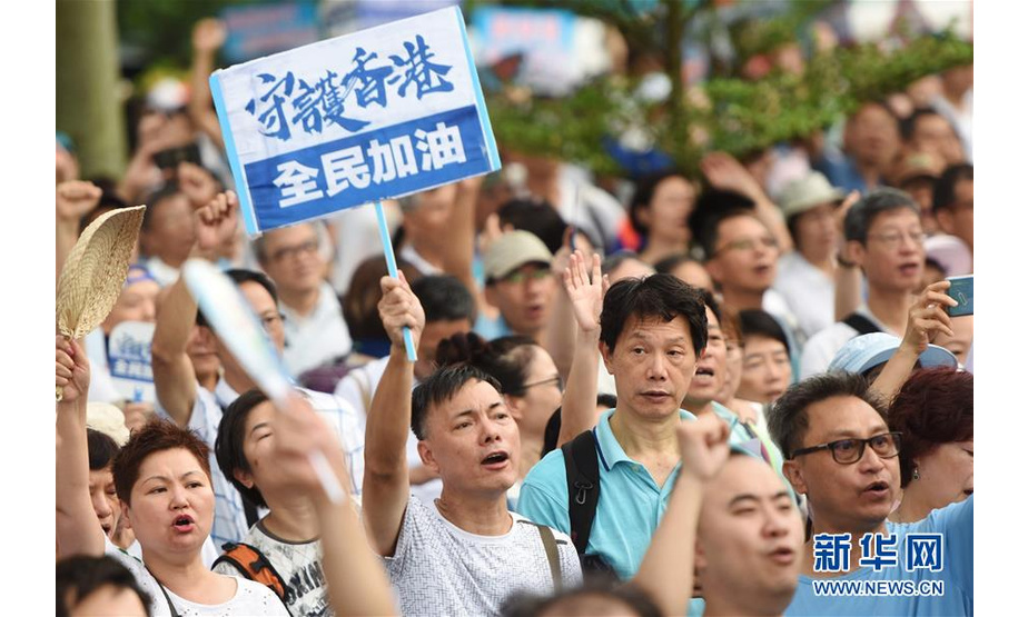7月20日，在香港添马公园，市民举起“守护香港”的标语。新华社记者 王申 摄