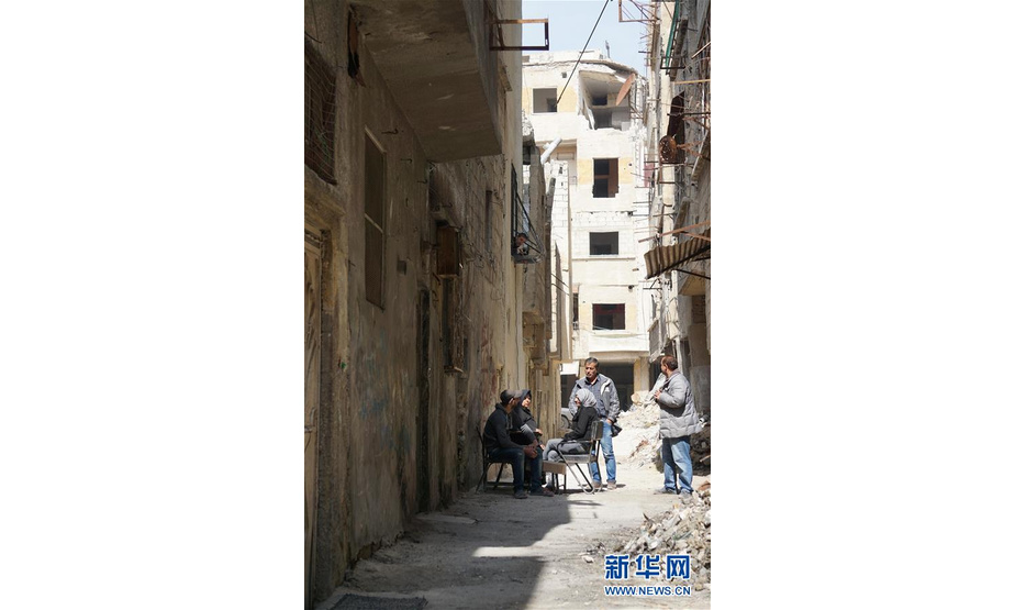 3月12日，在叙利亚大马士革东古塔地区，当地居民在居民楼旁交谈。 新华社记者汪健摄