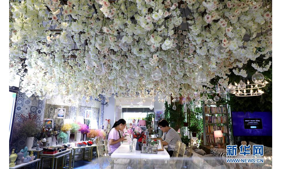 8月19日，在石家庄市桥西区李虹经营的花店内，工作人员在给顾客介绍“永生花”创意产品。 新华社记者 赵丹惠 摄