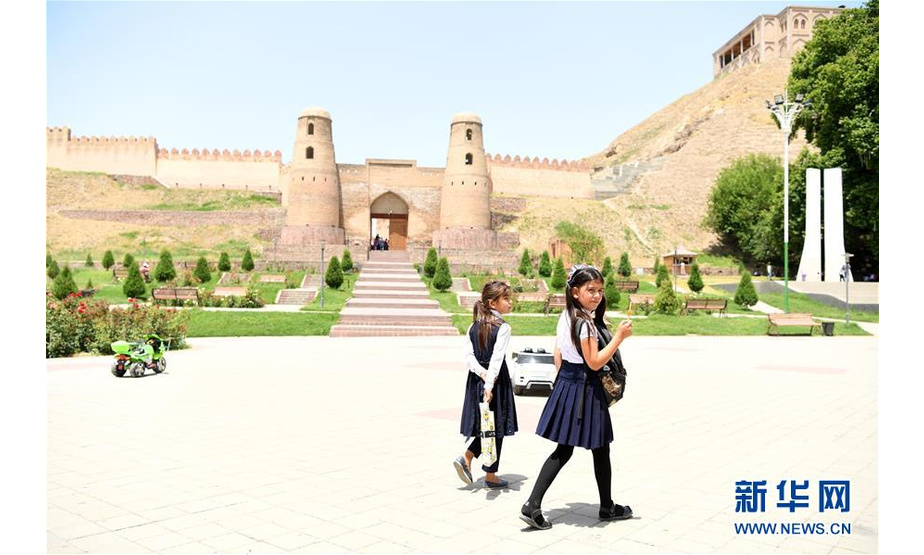 6月12日，在塔吉克斯坦首都杜尚别以西的吉萨尔，两名学生从吉萨尔城堡前走过。 吉萨尔城堡由煅烧过的红色砖块砌成，位于塔吉克斯坦首都杜尚别以西约25公里处，有着3000多年的历史。据苏联科学院和塔吉克斯坦学者考证，张骞从大宛回国时曾经过这里，收集了大量关于中亚腹地大宛、大夏、粟特地区的资料，为后世印证丝绸之路的繁盛提供了重要的地理信息。 新华社记者沙达提摄