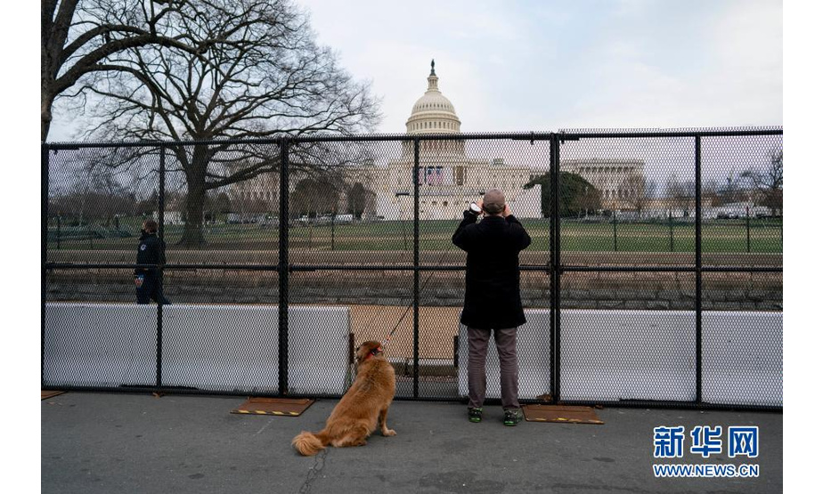 1月11日，在美国首都华盛顿，一名男子在国会大厦附近的隔离围栏外拍照。新华社记者 刘杰 摄