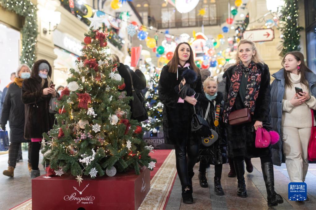 12月11日，在俄罗斯首都莫斯科的古姆百货商场，人们从新年枞树旁走过。

　　新华社记者白雪骐摄