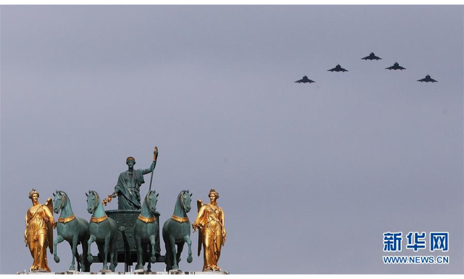 7月14日，在法国巴黎举行的国庆阅兵仪式上，法国空军飞机飞过卢浮宫金字塔广场附近的小凯旋门上空。 当日，法国在首都巴黎举行国庆阅兵仪式。 新华社记者 高静 摄