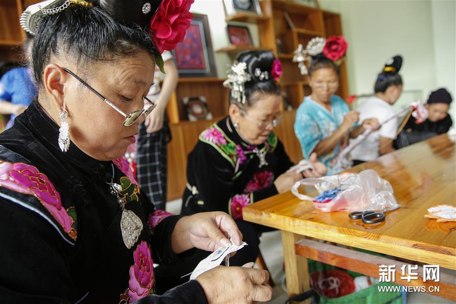 苗族手工艺人在贵州台江苗手工合作社扶贫工坊内进行苗绣制作（ 8月22日摄）。 “‘妈妈制造’使贫困地区的女性完全可以带着娃、绣着花、挣着钱、养着家，实现一种自由的有尊严的生活方式。”中国妇女发展基金会助理秘书长南静介绍。 “妈妈制造”公益项目由中国妇女基金会联合北京蚂蚁力量于2016年共同发起，希望通过对中华传统非遗手工艺的梳理，联合设计师共同创作具有东方文化符号、又符合国际化审美的文创产品，再交给具备一定生产技能的低收入女性制作，使这些女性通过劳动获得报酬、改善生活，从一定程度上解决空巢老人和留守儿童问题。 该项目启动至今将近三年的时间，已经在全国13个省建立了46家“妈妈制造”合作社，直接帮扶了4000多人创业和就业，推动当地的低收入女性居家就业、提高收入。项目通过“妈妈制造”平台的运营，吸引更多年轻人关注传统手工艺，有效促进了传统文化的传承；同时探索将非遗手工艺和现当代艺术相结合的模式，受到了公众的广泛认可：例如在与北京尤伦斯当代艺术中心的合作中，共同创新并发布了以毕加索的艺术风格为灵感、融合中国非遗艺术的手工艺品，包括贵州丹寨蜡染丝巾、贵州台江苗银耳环、江西景德镇骨瓷瓷盘、云南掇花绣抱枕、苗族蜡染笔记本等。 “妈妈制造”通过与知名设计师合作的方式，将小小的非遗手工艺品带出了大山，带着妈妈们的手艺和心意，向世界传播美和温暖。 新华社记者 张玉薇 摄