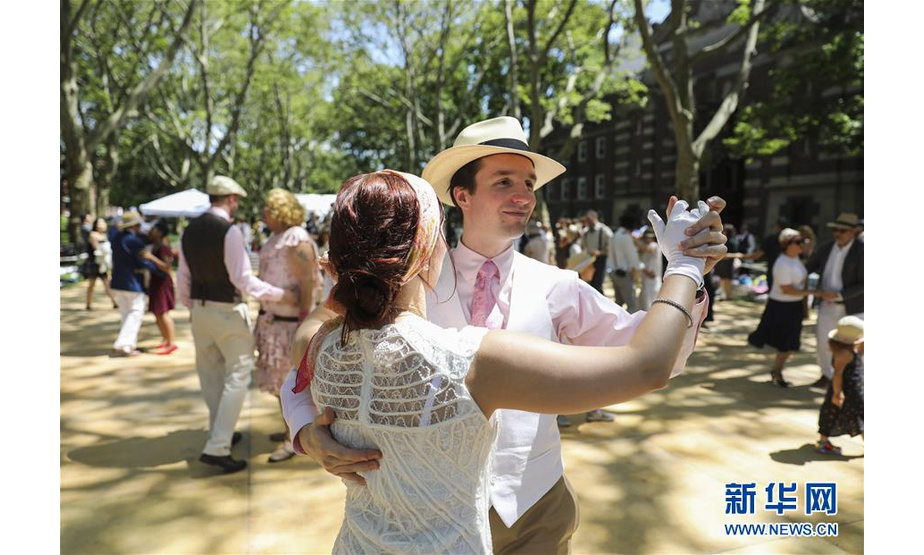 　6月15日，人们在美国纽约举行的“爵士时代草坪派对”上跳舞。 当日，第14届“爵士时代草坪派对”在纽约市总督岛举行。这项始于2005年的活动以二十世纪二十年代的爵士风潮为主题，上千名参与者身着复古服饰，伴着爵士音乐或翩翩起舞，或席地野餐，享受“时光倒流”的别样乐趣。 新华社记者 王迎 摄