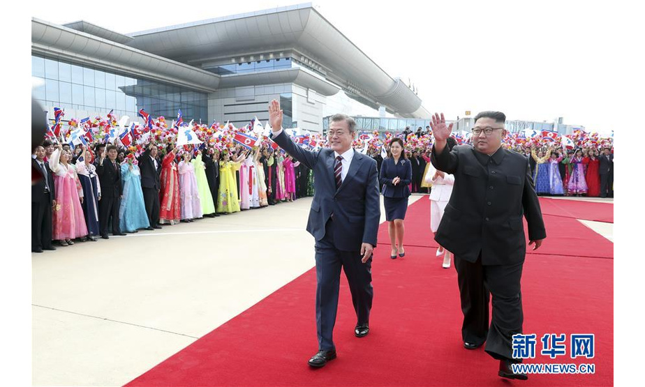 9月18日，韩国总统文在寅（前左）和朝鲜国务委员会委员长金正恩（前右）在平壤向欢迎群众挥手致意。  新华社发（韩朝首脑平壤会晤韩方联合采访团供图）
